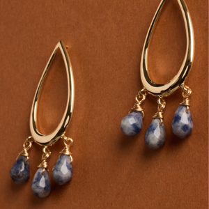 Gold teardrop earrings with three dangling blue, faceted beads wrapped in gold wire.