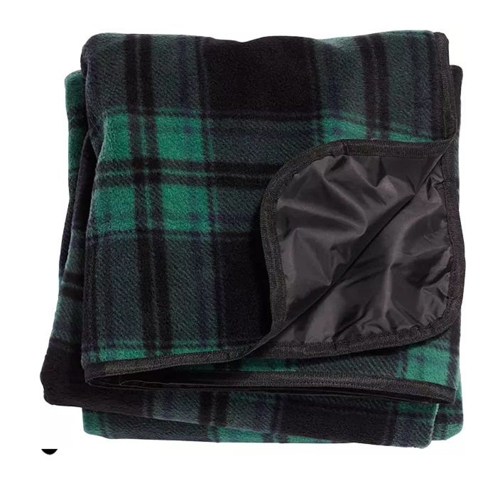 A folded black and green plaid blanket with a waterproof, black lining visible on one section.