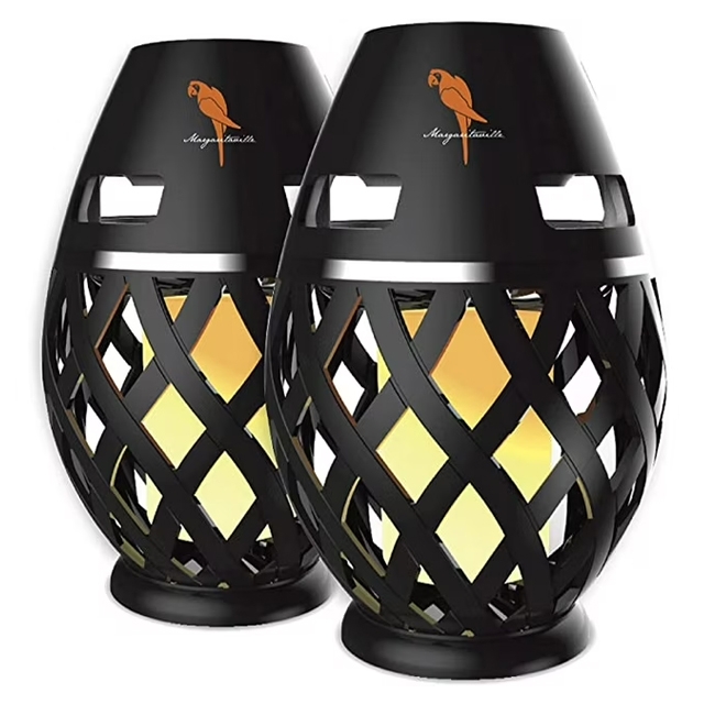 Two black Bluetooth tiki torch speakers with a lattice design, featuring integrated LED lights that mimic a flame effect. Each unit has a parrot logo on top.