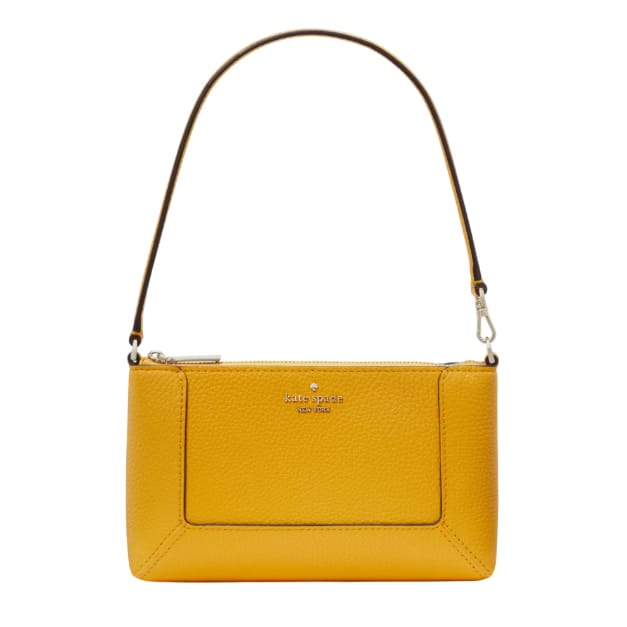A compact yellow leather wristlet from Kate Spade with a pebbled texture, featuring a zip closure, a front pocket, and a short strap for carrying.