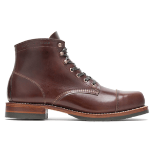 Brown leather lace-up boot with a cap toe, featuring sturdy stitching and a robust sole, marked \“Wolverine 1000 Mile\“ on the side.