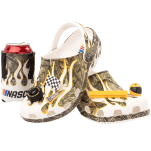 A pair of camo-patterned Crocs with flame designs and NASCAR-themed Jibbitz, accompanied by a NASCAR-branded can holder, featuring race-related decorations like a checkered flag.