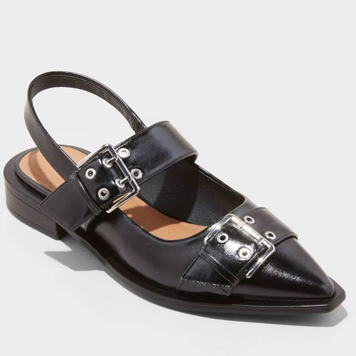 Black slingback flats with a pointed toe, featuring two adjustable straps with silver-tone buckles across the vamp.