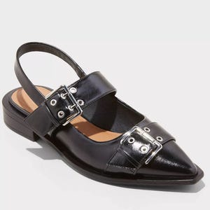 Black slingback flats with a pointed toe, featuring two adjustable straps with silver-tone buckles across the vamp.
