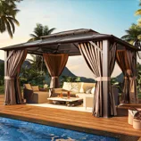 A gazebo with draped curtains and a seating area is set on a wooden deck beside a pool, surrounded by tropical plants and mountains in the background.
