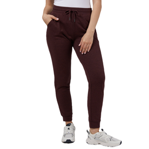 32 Degrees Comfort Tech Joggers are maroon, feature a drawstring waist, side pockets, and ribbed cuffs, paired with white athletic sneakers.