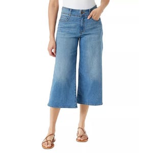 A person wearing light blue cropped wide-leg jeans and tan strappy sandals.