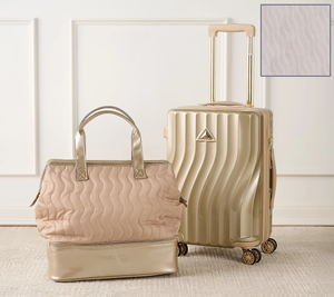 A wavy-textured cream-colored suitcase with dual spinner wheels is paired with a matching quilted tote bag featuring a metallic base and handles.