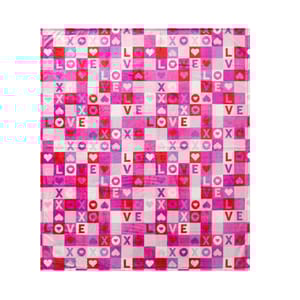 A colorful Valentine's Day throw featuring a grid pattern with pink, red, and purple squares. The design includes the words \“LOVE\“ and \“XOXO\“ along with heart motifs scattered throughout.