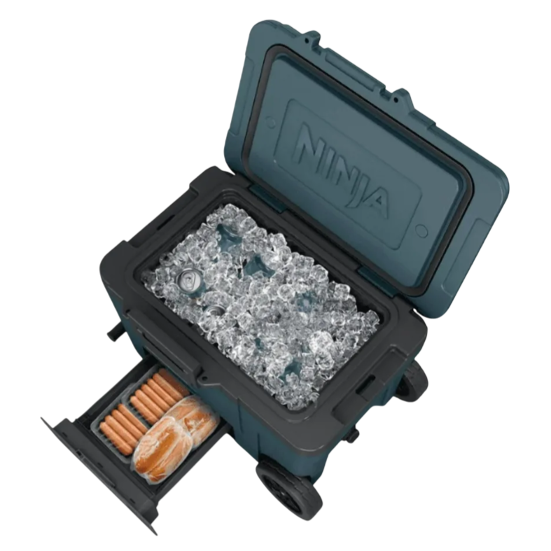 A cooler with wheels bearing the \“Ninja\“ logo is filled with ice and a beverage can, featuring a slide-out compartment containing hot dogs and buns.