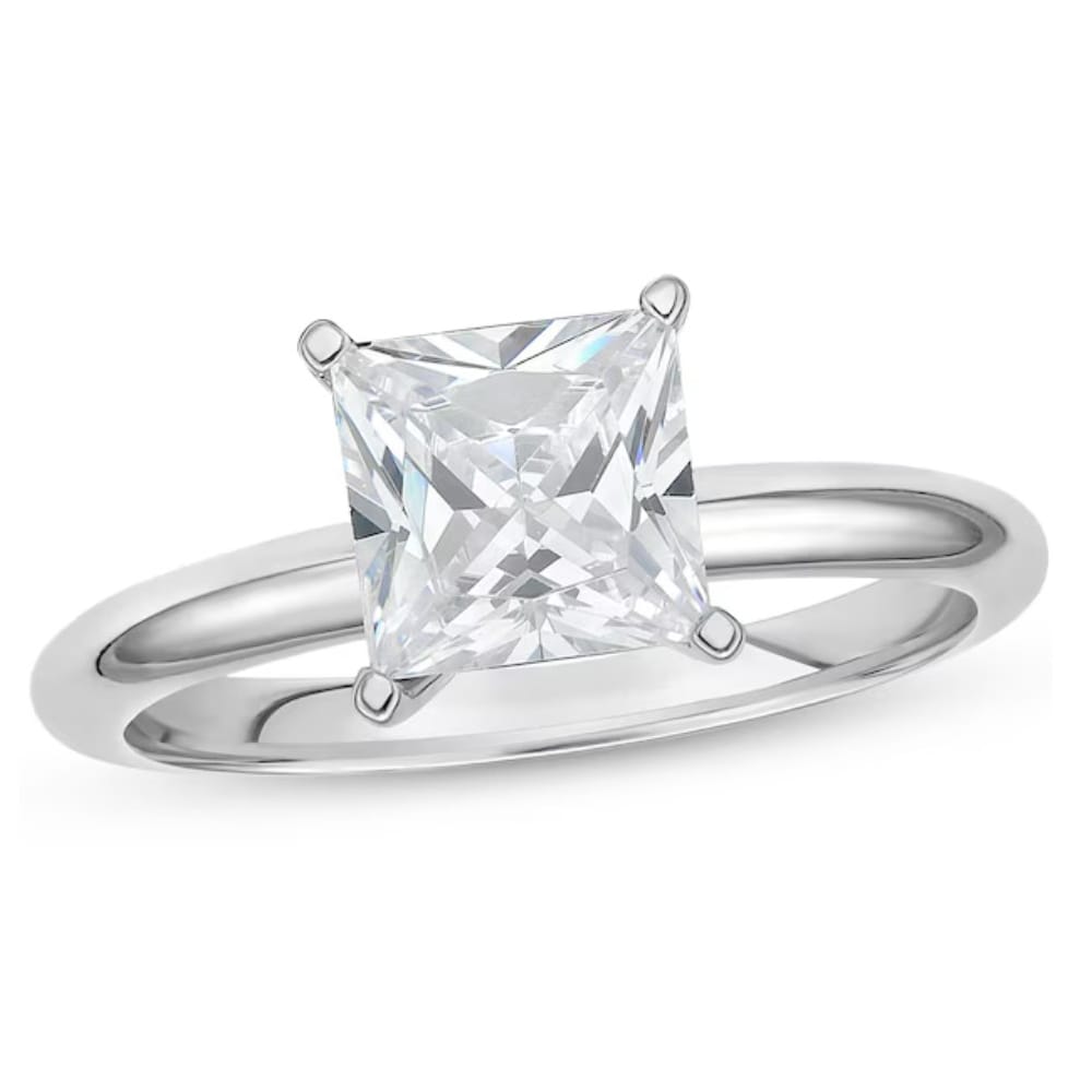 A silver ring featuring a large square-cut, clear gemstone set in a four-prong setting.