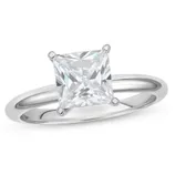 A silver ring featuring a large square-cut, clear gemstone set in a four-prong setting.