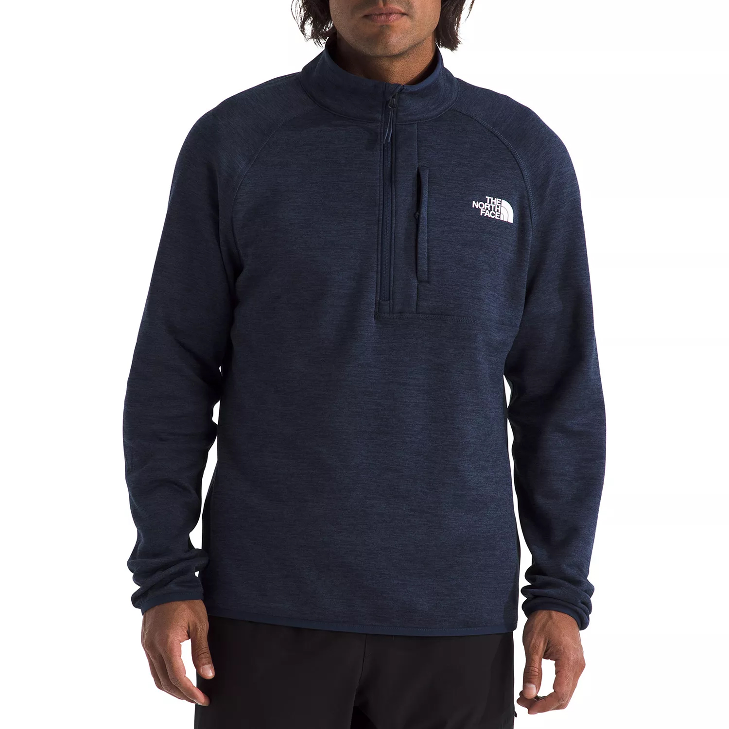 A man is wearing a navy blue The North Face quarter-zip pullover with a zipper pocket on the chest and the brand logo on the left side.