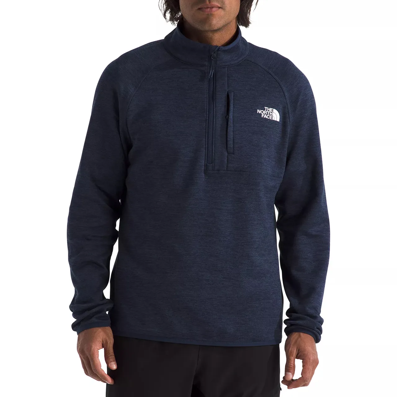 A man is wearing a navy blue The North Face quarter-zip pullover with a zipper pocket on the chest and the brand logo on the left side.
