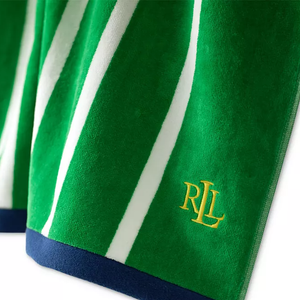Green and white striped beach towel with a navy border, featuring a yellow \“RL\“ logo embroidered on the fabric.