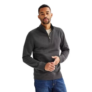 A male model is wearing a dark gray Sonoma quarter-zip sweater paired with blue jeans. The sweater features a high collar, a zipper halfway down the front, and a casual fit.