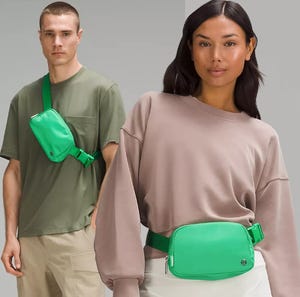 Two models are wearing matching bright green crossbody bags. The man has the bag across his chest, while the woman wears it around her waist.