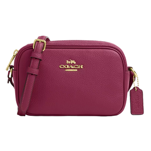 The Coach Mini Jamie Camera Bag is a compact, textured leather crossbody bag in a rich berry color, featuring gold-tone hardware, a front logo, and a detachable shoulder strap with an attached logo tag.