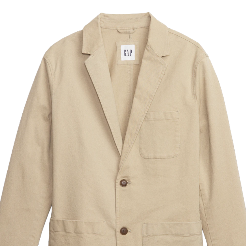 Beige blazer with two buttons, a left chest pocket, and two front pockets. Features a label with \“GAP\“ tag inside the collar.
