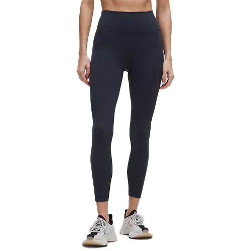 A person is wearing black leggings and athletic shoes. The photograph focuses on the lower half of their body, highlighting the fit and design of the leggings.