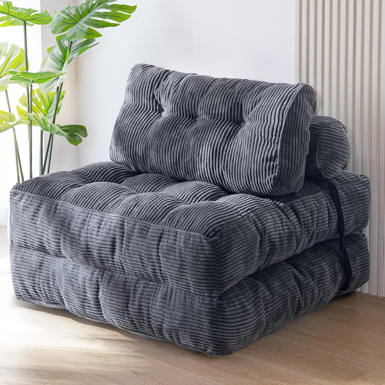 Gray foldable floor chair with a ribbed texture and plush cushioning, secured with a black strap.
