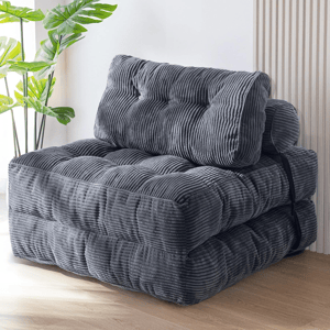 Gray foldable floor chair with a ribbed texture and plush cushioning, secured with a black strap.