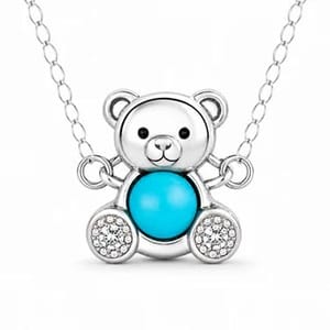 A teddy bear pendant necklace featuring a turquoise-colored body and sparkling accents on a silver chain.