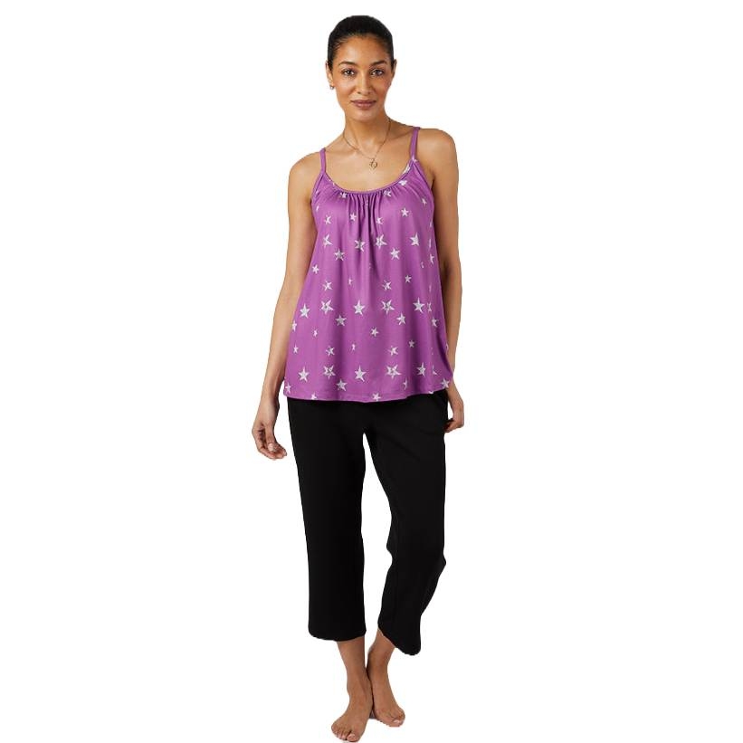 A woman is wearing a purple sleeveless top with white star patterns and black capri pants.