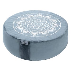A round, light blue cushion with a white mandala pattern on top, designed for yoga and meditation. It features a side label with \“Florensi\“ and is made of a soft, plush material.