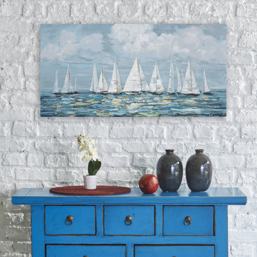 Vibrant blue console table with two vases, a flowerpot, a woven placemat, and a piece of fruit, set against a white brick wall with a sailboat painting above.