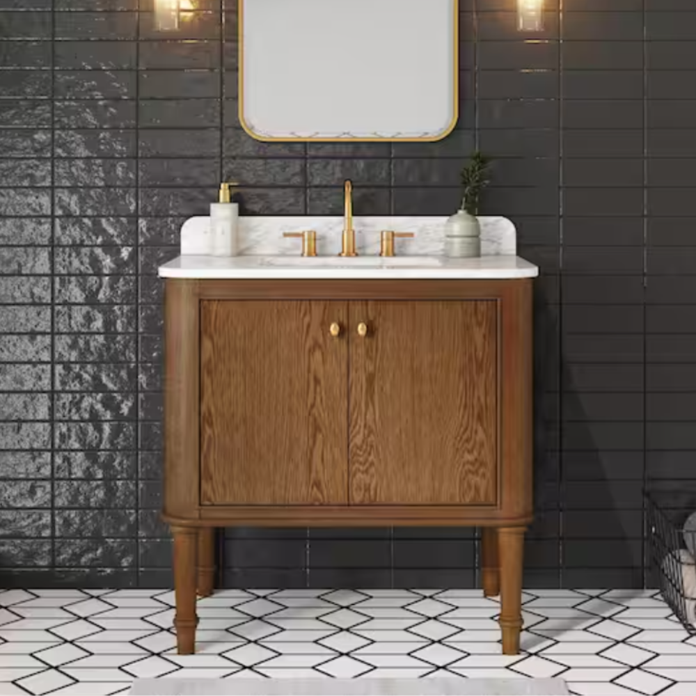A wooden bathroom vanity with a white countertop and gold fixtures stands against a glossy black tile wall. The floor features a white geometric tile pattern, complemented by two wall-mounted lights and a rectangular mirror above the vanity.