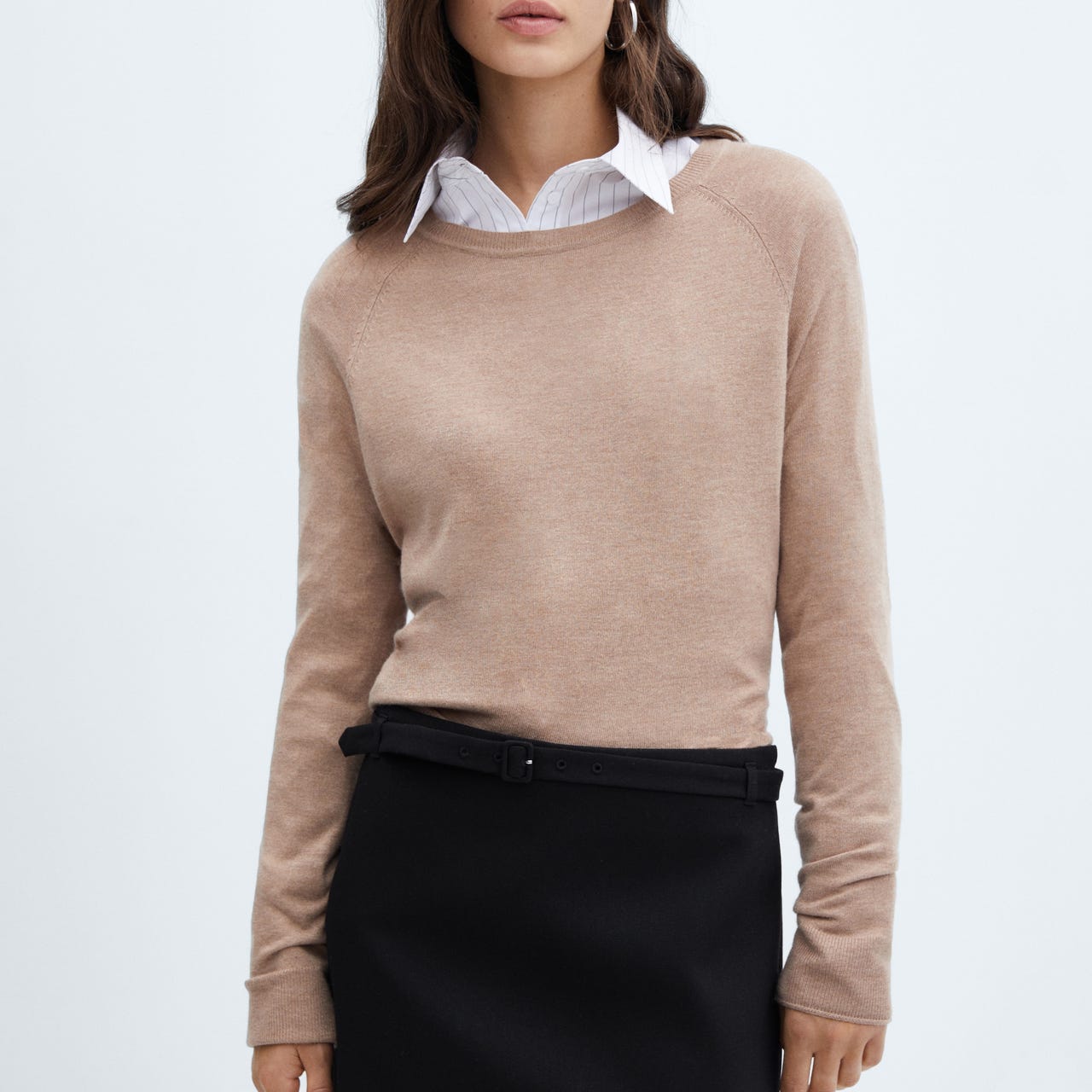 A black mini skirt with a straight cut and a waistband featuring a belt loop and a visible black belt.