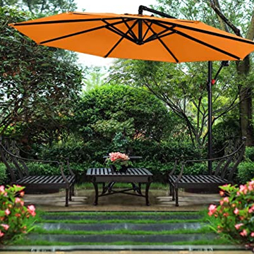 A large orange outdoor umbrella providing shade over a wooden patio set in a garden.