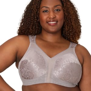 A woman wearing a taupe, floral-patterned, wireless bra with wide straps and lace trim.