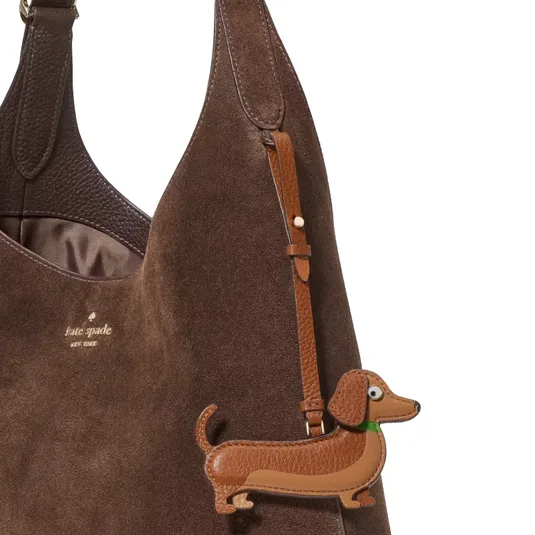 Brown suede shoulder bag with brown leather straps, featuring a cute dachshund dog charm attached.