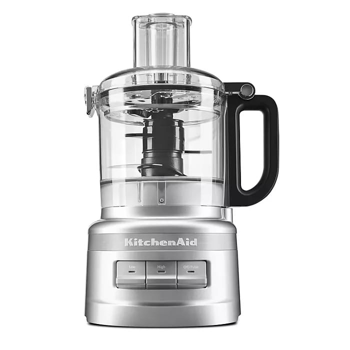 KitchenAid 7-Cup Food Processor in silver, featuring a transparent work bowl with a black handle, simple control buttons for low, high, and off/pulse settings, and a wide feed tube for easy ingredient addition.