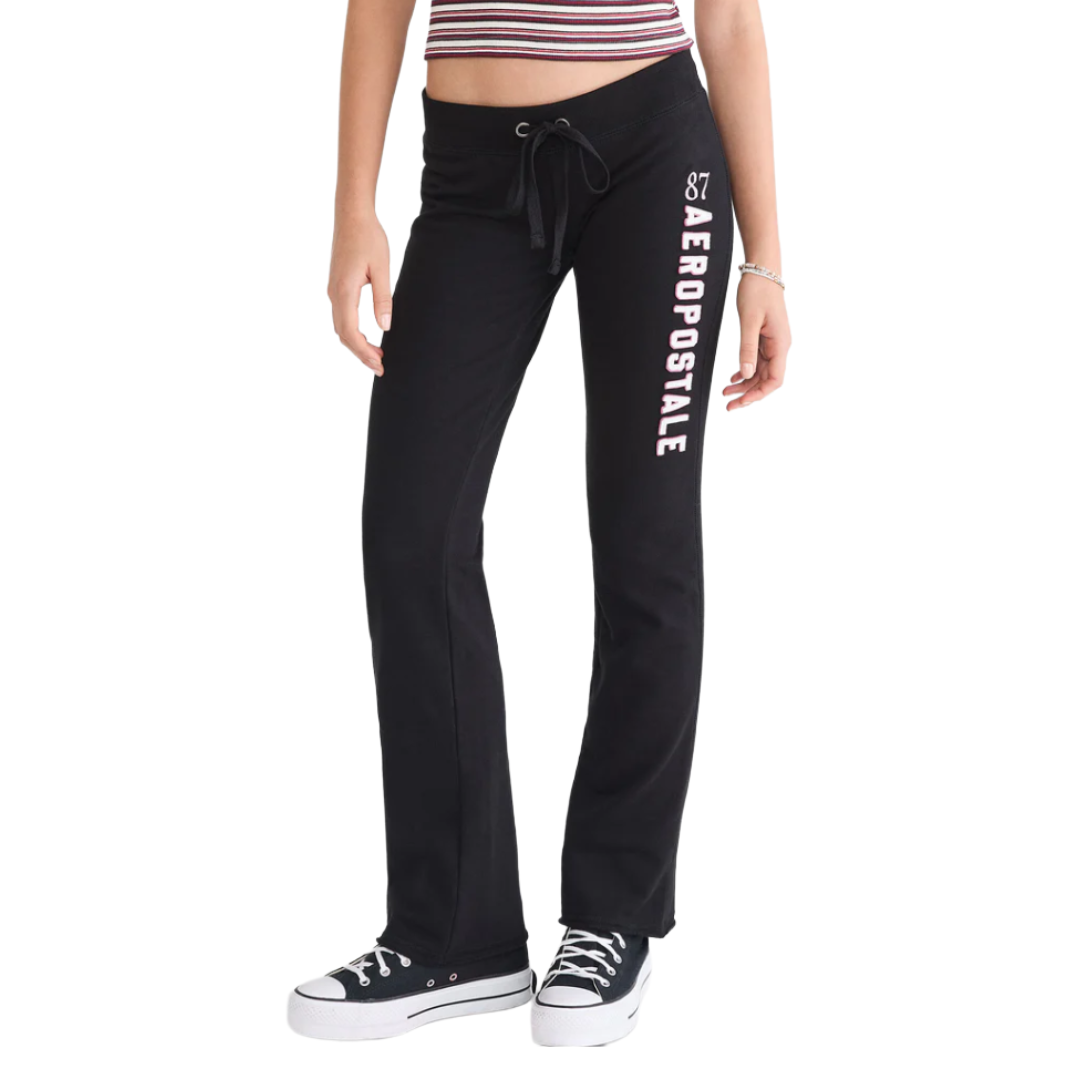 Black Aeropostale sweatpants with \“87\“ and vertical logo on the left leg, adjustable drawstring waistband, modeled with a striped crop top and black platform sneakers.