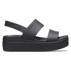 The Crocs Brooklyn Wedge Low Sandals are black platform sandals featuring two wide straps and an adjustable back strap with multiple holes for sizing, embodying a minimalist design with a comfortable elevated sole.