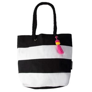 A black and white striped tote bag with black rope handles and a pink and yellow tassel accent.