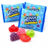 Jolly Rancher Gummies Minis are shown with packets and colorful fruit-shaped gummies in flavors like cherry, watermelon, apple, and grape.