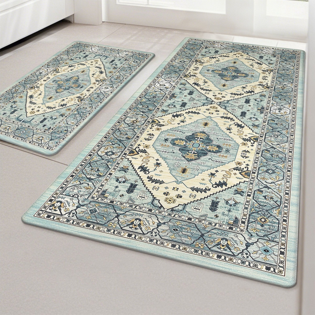 A set of two decorative area rugs featuring a vintage-style geometric pattern in light blue and cream tones, placed on a tiled floor.