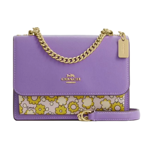 A purple Coach handbag with a chain strap, featuring a floral pattern with yellow and white flowers on the front pocket.