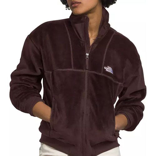 A person is wearing a dark-colored, full-zip fleece jacket with the logo of The North Face on the left chest area.