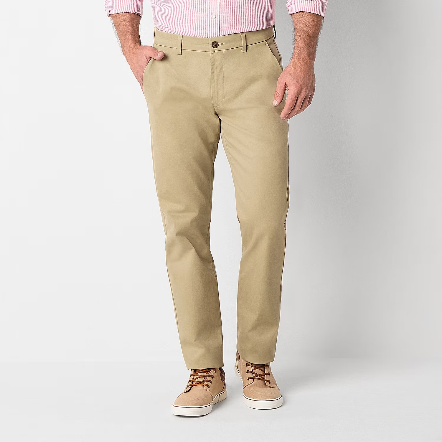 A person wearing khaki chinos paired with beige lace-up sneakers.