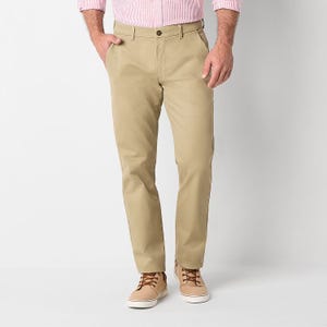 A person wearing khaki chinos paired with beige lace-up sneakers.