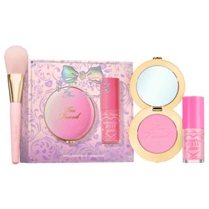 Too Faced makeup set including a pink blush and lip gloss duo with a brush. The packaging is adorned with a bow design.