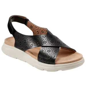 A black sandal with perforated floral patterns on wide straps and a cushioned beige footbed, featuring a white sole and an adjustable back strap.
