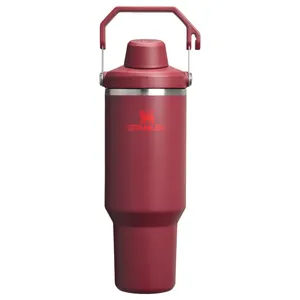 A red Stanley travel mug with a handle, featuring a leak-proof lid.