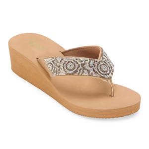 Mixit sandals feature a beige wedge heel and a thong strap adorned with sparkling gemstones in a circular pattern, offering stylish comfort.