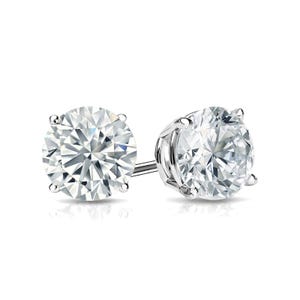 A pair of round, brilliant-cut diamond stud earrings set in a four-prong white metal setting.